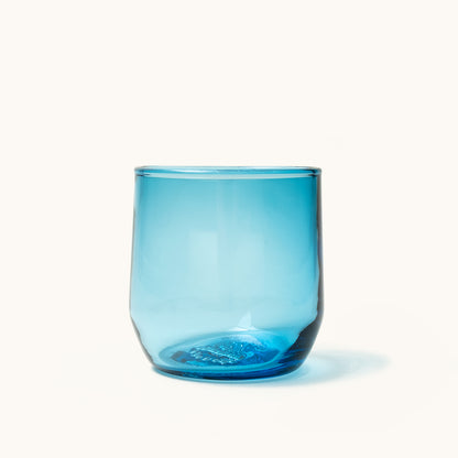 Translucent blue cocktail glass featuring a thick base with internal bubble details.