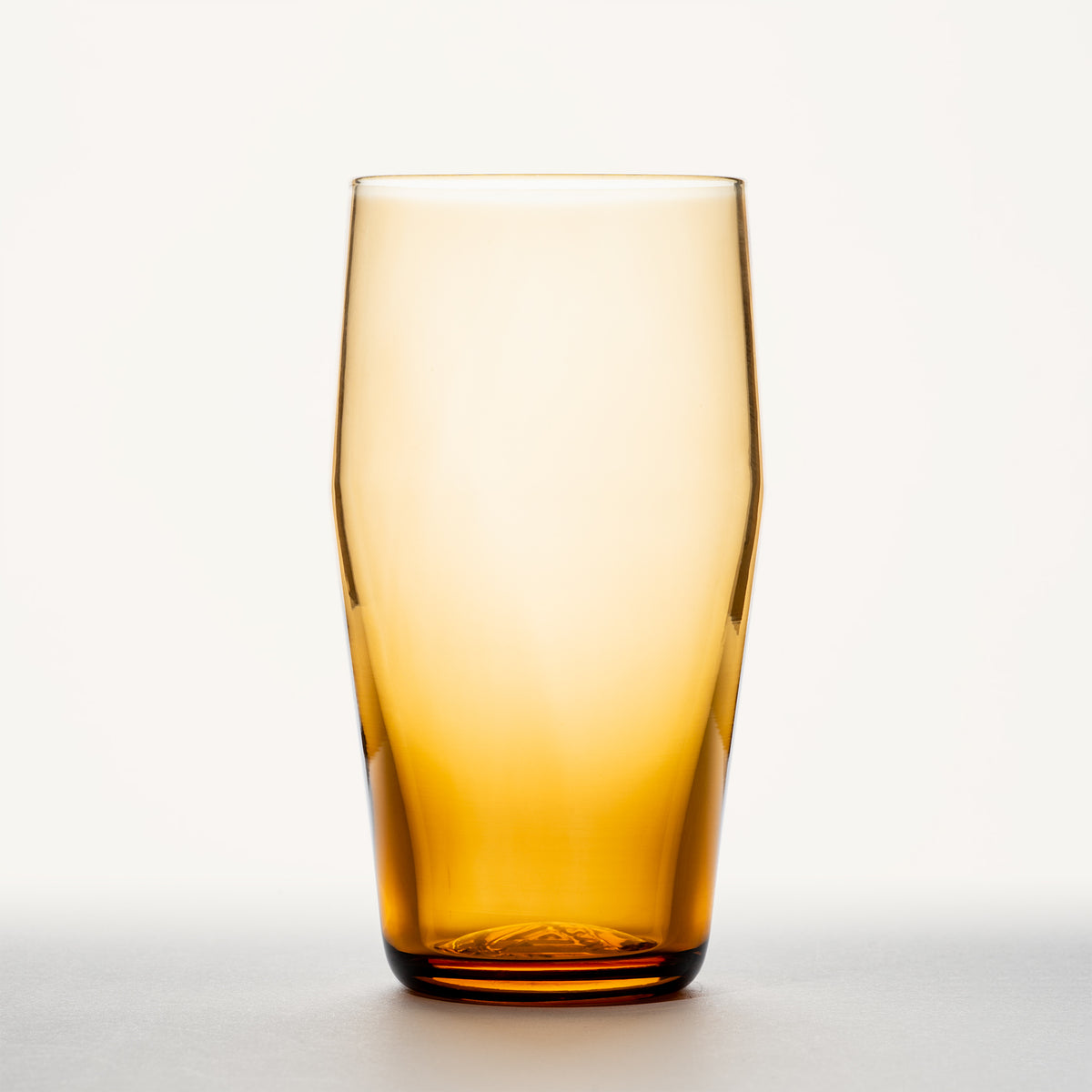 Amber glass standard pint with a thick base, shown upright against a plain white background.