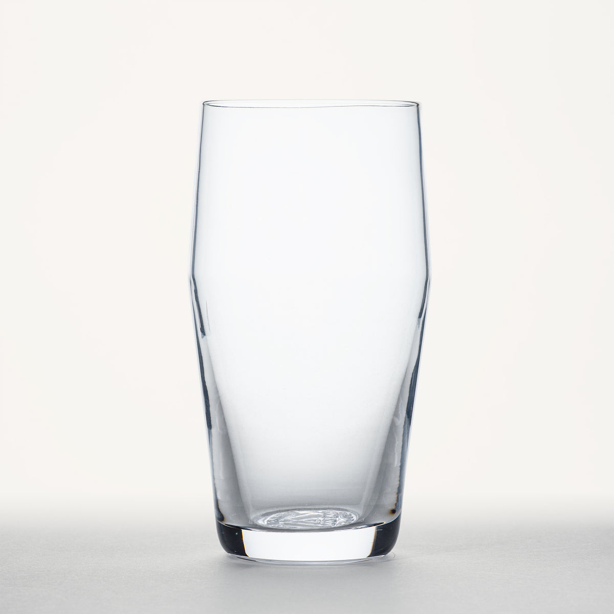 Clear standard pint glass with tapered sides and thick base, shown in front view against a plain white background.