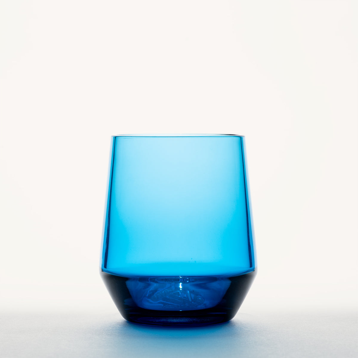 Translucent blue wine glass with a thick, darker base and tapered bowl shape, shown front-on against a white background.