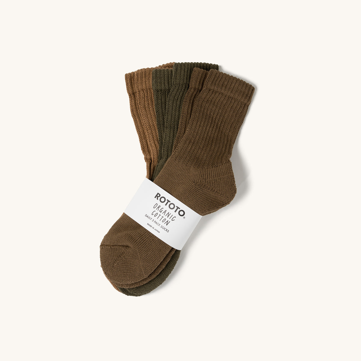 Khaki mini crew socks 3-pack by Rototo, ribbed organic cotton with paper band on cream background