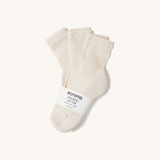 Ivory mini crew socks by Rototo, a 3-pack with ribbed cuffs and an organic cotton band on a cream background.