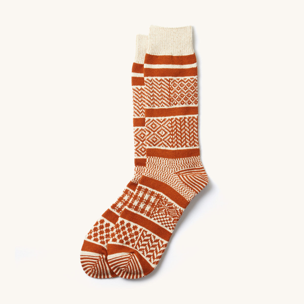 Ivory and rust multi jacquard crew socks featuring various geometric patterns, laid flat.