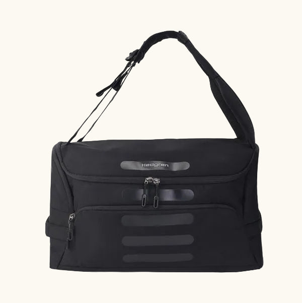 Black duffle bag by Hedgren with a wide shoulder strap, dual top zippers, and lower horizontal accent strips.