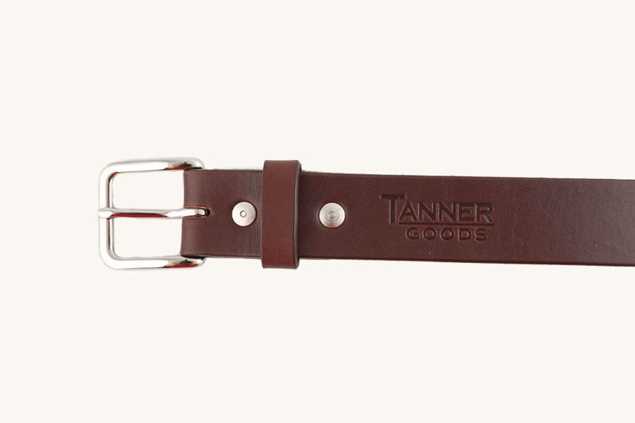 Cognac leather belt from Tanner Goods with a silver-tone buckle and rivets.