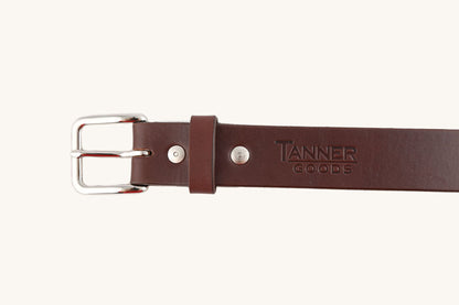 Cognac leather belt from Tanner Goods with a silver-tone buckle and rivets.
