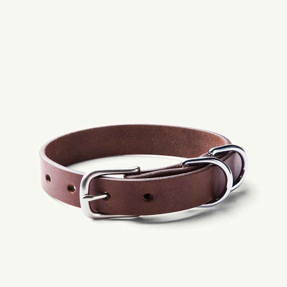 Classic cognac leather dog collar with a silver-tone buckle and two D-rings.