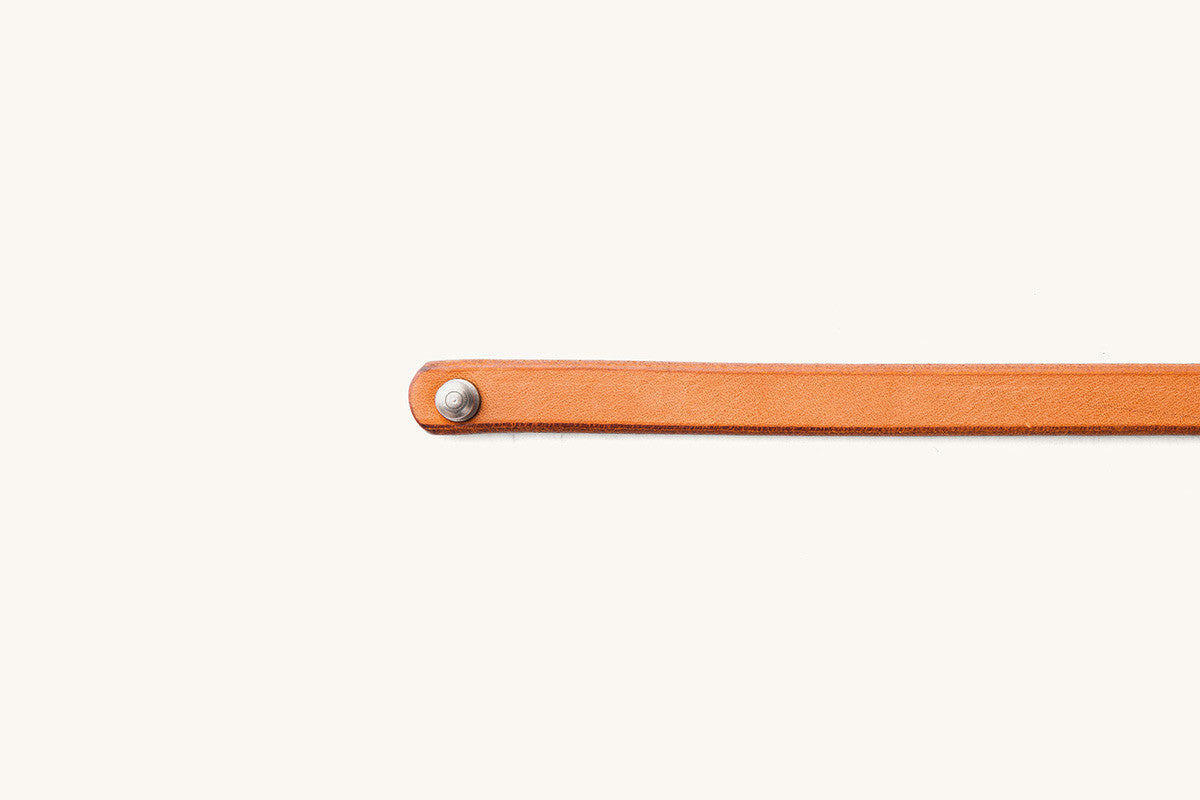 Saddle Tan leather single wrap wristband with a silver-toned rivet.
