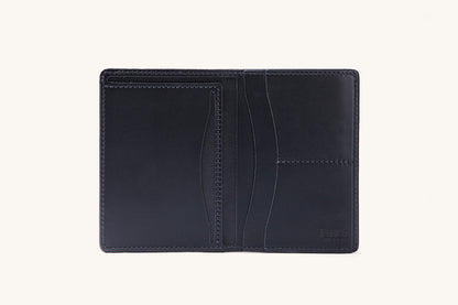 Smooth black travel wallet, open flat, revealing multiple card slots, slip pockets, and a debossed logo.